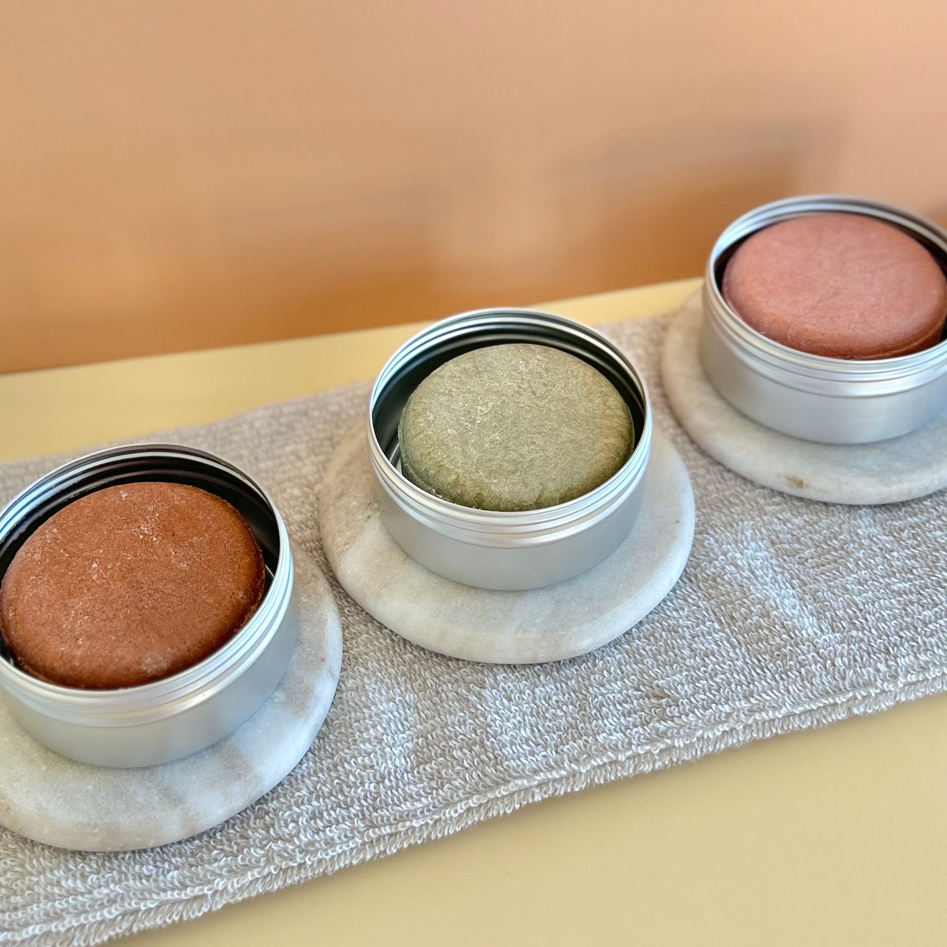 All three shampoo bars displayed in travel tin